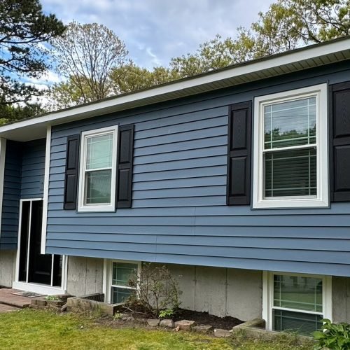 Contractor installing siding panels on house